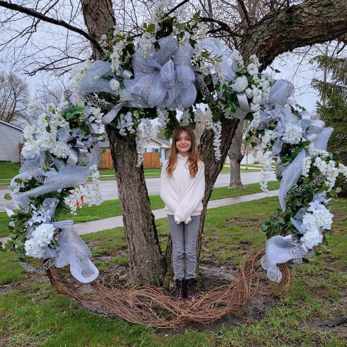 White floral wreath arch outdoors
